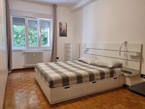 a bedroom with a bed in a white room at Apt by Trieste University in Trieste