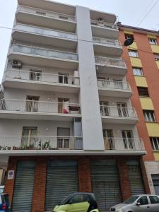 a tall apartment building with cars parked in front of it at Apt by Trieste University in Trieste