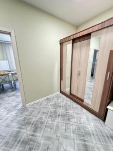 um quarto vazio com uma porta e um espelho em Комфортные апартаменты в ЖК Сконур рядом с Жекпе-Жек em Aqtöbe