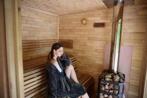 a woman is sitting in a sauna at База відпочинку Forest Stream in Svalyava