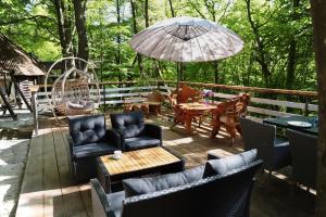 a patio with chairs and tables and an umbrella at База відпочинку Forest Stream in Svalyava