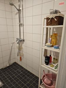 y baño con ducha y suelo de baldosa negra. en Viihtyisä rivitalokolmio autopaikalla, en Kangasala