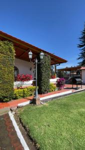 une maison avec un banc et des fleurs dans une cour dans l'établissement Hacienda Le Plus, à Quito