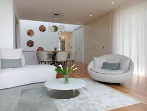 a living room with a white couch and a table at Villa Amendoa in Arco da Calheta