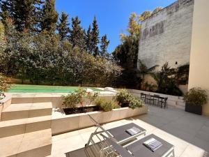a patio with tables and chairs and a tennis court at Carlo V - con piscina e giardino privati in Lecce
