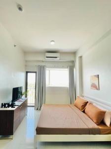 a bedroom with a large bed and a television at WV 6 Simple and Cozy in Iloilo City