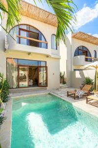 una villa con piscina di fronte a una casa di Amani Villas: New, Luxury, Mediterranean, Private Pool, Canggu a Canggu