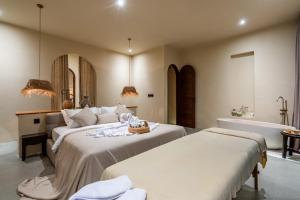2 letti in una camera con vasca e lavandino di Amani Villas: New, Luxury, Mediterranean, Private Pool, Canggu a Canggu