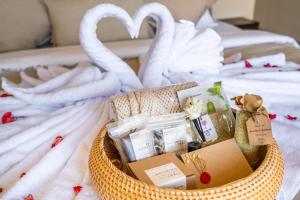 a basket filled with gifts on a bed at Amani Villas: New, Luxury, Mediterranean, Private Pool, Canggu in Canggu