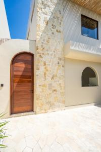 una porta di legno sul lato di una casa di Amani Villas: New, Luxury, Mediterranean, Private Pool, Canggu a Canggu