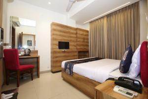 una camera con letto, scrivania e sedia di Hotel RV Regency ad Amritsar
