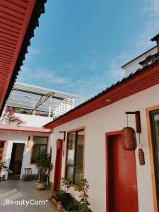 uma casa branca com um telhado vermelho e uma porta vermelha em Zhangjiajie Tingyutang Little Yard em Zhangjiajie