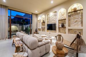 un soggiorno con parete in pietra di Amani Villas: New, Luxury, Mediterranean, Private Pool, Canggu a Canggu