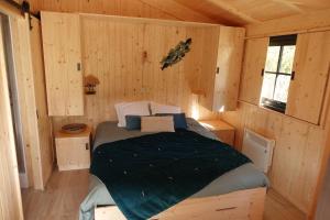 Camping L'Ondine de Provence في La Motte-Chalançon: غرفة نوم مع سرير في كابينة خشب