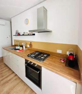 a kitchen with a stove and a wooden counter top at Nuovo bilocale a due passi dal centro e dal mare Castiglione in Castiglione della Pescaia +12 photos