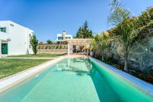 a swimming pool in the backyard of a house at Heliophos Villa Aelia in Kiotari +39 photos