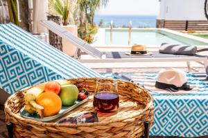 uma cesta de frutas e um copo de vinho sobre uma mesa em Heliophos Villa Aelia em Kiotari