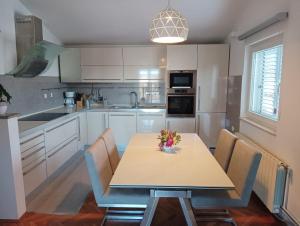 a kitchen with a table with a vase of flowers on it at Neptun in Primošten