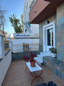 un bâtiment avec un banc et une table sur une terrasse dans l'établissement APARTAHOTEL DOÑA REYES, à Chipiona