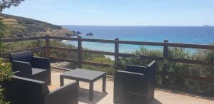 Una mesa y sillas en un balcón con vista al mar. en Casa Alice vicino al mare, en Porto Pino 16 fotos más
