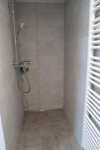 ギュンツブルクにあるGästewohnung in Massivholzhausのシャワーヘッド付きのシャワー付きのバスルーム +9枚の写真