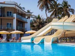 a slide in a swimming pool at a resort at Kombo Beach Resort in Serekunda