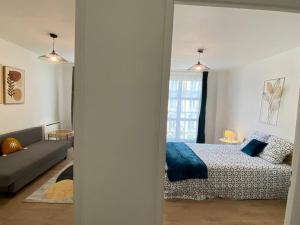 Appartement 2 chambres avec cuisine Gare في غرونوبل: غرفة نوم بسرير واريكة في غرفة