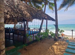 um restaurante na praia com vista para o oceano em Panorama Beach Hotel em Tangalle