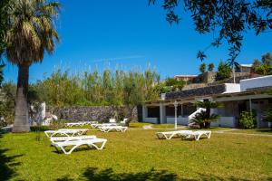 un gruppo di tavoli da picnic bianchi sull'erba vicino a un edificio di Residence Palummera a Ischia