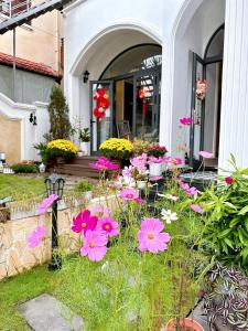 a bunch of flowers in front of a house at Moon Homestay in Thôn Kim Long (1)