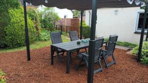 a black table and chairs under an umbrella at Ferienhaus Hansühn "gerne mit Hund" in Hansühn