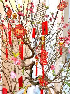 uma árvore decorada com vermelhos e flores cor-de-rosa em Moon Homestay em Thôn Kim Long (1)