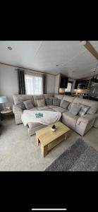 The Luxe Lodge, Skipsea Sands Bridlington في Ulrome: غرفة معيشة مع أريكة وطاولة قهوة