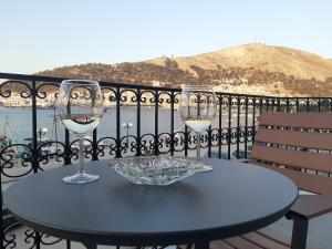 a table with two glasses of wine on a balcony at Yatrissa Boutique Apartments in Kalymnos
