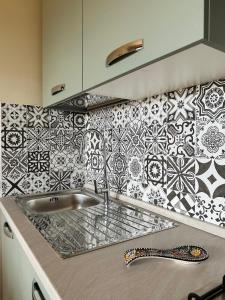 um balcão de cozinha com um lavatório e azulejos pretos e brancos em StanzeLatina em Latina