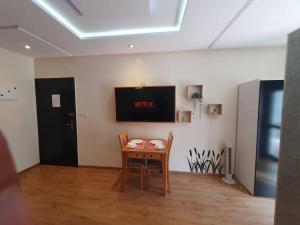 Habitación con mesa y TV en la pared. en DOUBLE Studio en Rabat