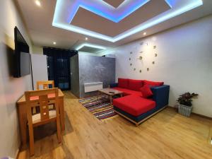 un soggiorno con divano rosso e tavolo di DOUBLE Studio a Rabat