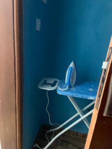 ein blaues Zimmer mit einem Schreibtisch und einem Telefon darauf in der Unterkunft Jay Apartments in Mbarara
