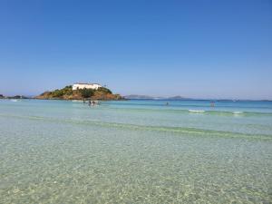 a beach with a house on an island in the water at AP encantador na Praia do Forte! (208) in Cabo Frio
