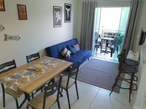uma sala de estar com um sofá azul e uma mesa em AP encantador na Praia do Forte! (208) em Cabo Frio