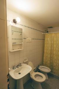 a bathroom with a sink and a toilet and a mirror at Hosteria Pia Guapi in Colón