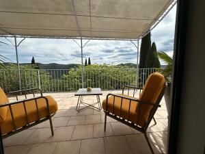 a patio with two chairs and a table on a balcony at Bastide Saint-Thomé in Saint-Thomé