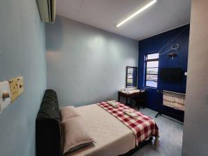 een slaapkamer met een bed en een bureau. bij Deummah Guest Room in Cukai