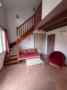 een woonkamer met een trap en een rode bank bij La villa De Lina 431 -Self Check In - in Gallargues-Le-Montueux