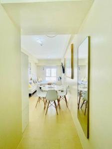 una sala da pranzo con tavolo, sedie e uno specchio di N2 Sleek Urban Escape a Città di Iloilo