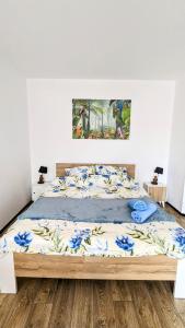 a bed in a bedroom with a painting on the wall at ISLAND4U in Gdańsk
