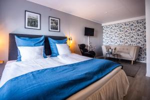 ein Schlafzimmer mit einem blauen und weißen Bett und einem Stuhl in der Unterkunft Marsk Hotellet in Højer