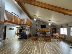 una gran sala de estar con suelo de madera y chimenea en AmericInn by Wyndham Oscoda Near AuSable River, en Oscoda