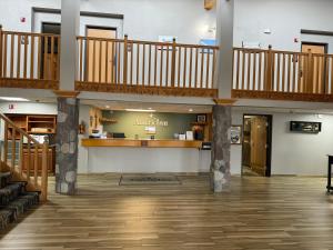 a large lobby with a staircase and a pharmacy at AmericInn by Wyndham Oscoda Near AuSable River in Oscoda