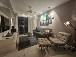 un salon avec un canapé et deux chaises dans l'établissement Lindo AP completo em Cabo Frio, à Cabo Frio